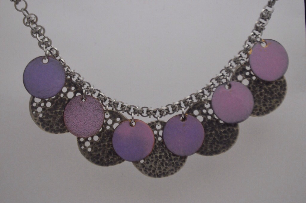 Stainless steel necklace with large pink enamel and textured metal circles. 
